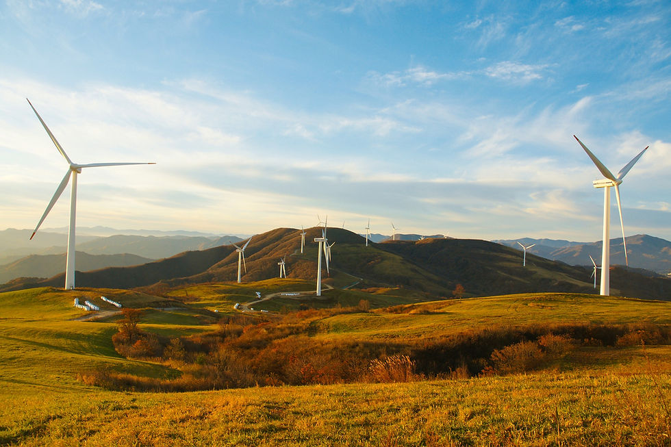 11 modern wind turbines on a green hillside.